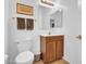 Bright bathroom featuring a wooden vanity with a white countertop, framed mirror, and a toilet at 13965 N 135Th Dr, Surprise, AZ 85379