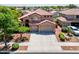 This home features a three-car garage, desert landscaping, and mature trees at 13965 N 135Th Dr, Surprise, AZ 85379