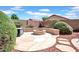Enjoy the cozy outdoor fire pit surrounded by lush desert landscaping in this backyard at 13965 N 135Th Dr, Surprise, AZ 85379