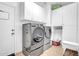 Spacious laundry room features a modern washer and dryer, complemented by white cabinets for ample storage at 13965 N 135Th Dr, Surprise, AZ 85379