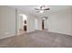 Spacious bedroom with neutral paint, carpet, ceiling fan, and bathroom access at 17429 W Red Bird Rd, Surprise, AZ 85387