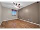 Spacious bedroom with hardwood floors, ceiling fan, and a bright window at 17429 W Red Bird Rd, Surprise, AZ 85387
