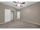 Bedroom featuring neutral carpet, ceiling fan, and a double-door closet at 17429 W Red Bird Rd, Surprise, AZ 85387