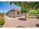 Home exterior featuring a covered patio, desert landscaping, and mature shade trees at 17429 W Red Bird Rd, Surprise, AZ 85387