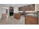 Well-equipped kitchen boasts an island, stainless appliances, granite countertops, and dark wooden cabinetry at 17429 W Red Bird Rd, Surprise, AZ 85387