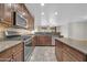 Modern kitchen with stainless steel appliances, granite countertops, and wooden cabinets at 17429 W Red Bird Rd, Surprise, AZ 85387