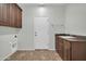 Bright laundry room with upper cabinets, sink, and white door at 17429 W Red Bird Rd, Surprise, AZ 85387