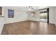 Bright living room with hardwood floors, neutral paint, and sliding door access to patio at 17429 W Red Bird Rd, Surprise, AZ 85387