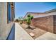 View of the side yard with gravel, stepping stone walkway, and mature landscaping at 17429 W Red Bird Rd, Surprise, AZ 85387