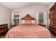 Bright bedroom featuring a decorative wood bed frame, hardwood floors, and side tables at 18415 W Surprise Farms N Loop, Surprise, AZ 85388