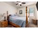 Simple bedroom featuring carpet flooring, a wooden bed frame, and a window with natural light at 18415 W Surprise Farms N Loop, Surprise, AZ 85388