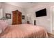Warm bedroom featuring a TV, an armoire, and soft lighting for a cozy atmosphere at 18415 W Surprise Farms N Loop, Surprise, AZ 85388