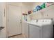 Functional laundry room featuring a side-by-side washer and dryer with storage shelves above at 18415 W Surprise Farms N Loop, Surprise, AZ 85388