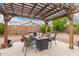 Cozy backyard seating area under a charming pergola, perfect for enjoying the outdoors at 18415 W Surprise Farms N Loop, Surprise, AZ 85388