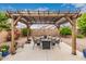 Backyard pergola with outdoor seating area, creating a cozy space for relaxing and entertaining at 18415 W Surprise Farms N Loop, Surprise, AZ 85388