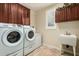 Efficient laundry room equipped with modern washer, dryer, and built-in cabinets at 2111 E Azalea Dr, Chandler, AZ 85286