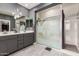 Well lit bathroom features a double vanity, a walk in shower, gray cabinets, and tile floors at 22495 E Silver Creek Ln, Queen Creek, AZ 85142