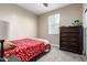 Cozy bedroom with a large window, plush carpet, and a wooden dresser at 22495 E Silver Creek Ln, Queen Creek, AZ 85142