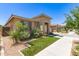 Landscaped home exterior featuring a lush lawn, desert accents, neutral paint, and well-maintained curb appeal at 22495 E Silver Creek Ln, Queen Creek, AZ 85142