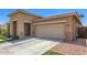 Home exterior with an attached garage, desert landscaping, and a driveway leading to a welcoming entryway at 22495 E Silver Creek Ln, Queen Creek, AZ 85142