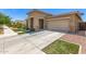 Home exterior view with a large driveway, desert landscaping, and well-maintained greenery, and neutral paint at 22495 E Silver Creek Ln, Queen Creek, AZ 85142