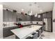 Modern kitchen features stainless steel appliances, a large island, gray cabinets and stylish pendant lighting at 22495 E Silver Creek Ln, Queen Creek, AZ 85142