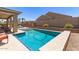 Lush backyard showcasing a sparkling pool with a baja step, barbecue, and covered patio space at 22495 E Silver Creek Ln, Queen Creek, AZ 85142