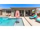 Stunning backyard pool area featuring a built-in baja shelf, covered patio, and comfortable seating at 22495 E Silver Creek Ln, Queen Creek, AZ 85142