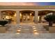 Luxury home's covered patio with stone steps, recessed lights, and outdoor seating overlooking the backyard at 22610 N 80Th Pl, Scottsdale, AZ 85255