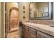 Beautiful bathroom with stone countertops, decorative mirror, and walk-in shower with elegant tile work at 22610 N 80Th Pl, Scottsdale, AZ 85255