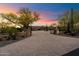 Gated estate entrance featuring mature trees, desert vegetation, and a circular driveway leading to a luxurious home at 22610 N 80Th Pl, Scottsdale, AZ 85255