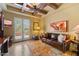 Relax in this living room featuring a leather sofa, area rug, and French doors to the patio at 22610 N 80Th Pl, Scottsdale, AZ 85255