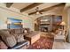 Relaxing living room area boasting wood beams, a stone fireplace, and cozy furniture at 22610 N 80Th Pl, Scottsdale, AZ 85255
