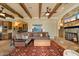 Inviting living room featuring wood beams, a stone fireplace, and bar area at 22610 N 80Th Pl, Scottsdale, AZ 85255