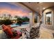 Covered patio featuring comfortable outdoor furniture, overlooking a pool with lush landscaping and mature trees at 22610 N 80Th Pl, Scottsdale, AZ 85255