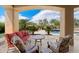 An outdoor patio provides stylish seating and a beautiful view of the serene pool and lush landscaping at 22610 N 80Th Pl, Scottsdale, AZ 85255