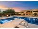 Inviting pool with baja step and travertine tile and outdoor seating area with fire pit at 22610 N 80Th Pl, Scottsdale, AZ 85255