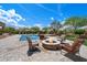 Relaxing outdoor space with a luxurious pool, stone fire pit, and comfortable seating area under a beautiful sky at 22610 N 80Th Pl, Scottsdale, AZ 85255