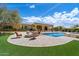Expansive backyard featuring a sparkling pool, fire pit, and lush green lawn perfect for outdoor entertaining at 22610 N 80Th Pl, Scottsdale, AZ 85255