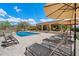 Tranquil backyard featuring a refreshing pool, comfortable lounge chairs, and serene desert landscaping at 22610 N 80Th Pl, Scottsdale, AZ 85255