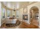 Cozy sitting room with a fireplace, comfortable seating, and arched doorway, perfect for relaxation and unwinding at 22610 N 80Th Pl, Scottsdale, AZ 85255