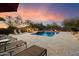 Backyard swimming pool with sun loungers, a spa, lush landscaping, and evening lighting at 22610 N 80Th Pl, Scottsdale, AZ 85255