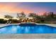 Tranquil pool with integrated spa, set against an artful landscape with fire bowls and mature desert trees at 22610 N 80Th Pl, Scottsdale, AZ 85255