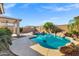 Beautiful backyard pool with rock features, lush palms, and mature desert plants at 2272 W Jasper Butte Dr, Queen Creek, AZ 85144