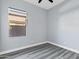 Empty bedroom featuring gray wood floors and a window with privacy shades at 2272 W Jasper Butte Dr, Queen Creek, AZ 85144
