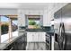 Bright kitchen boasts granite countertops, white cabinets, stainless steel appliances, and backyard views at 2272 W Jasper Butte Dr, Queen Creek, AZ 85144