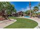 Spacious backyard with lush green lawn, inviting pool, and outdoor play area, ideal for entertaining at 30 W Sheffield Ave, Gilbert, AZ 85233