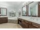 A luxurious bathroom featuring a soaking tub with views, dual vanities, and stylish fixtures at 30 W Sheffield Ave, Gilbert, AZ 85233