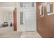 Bright foyer with a white door, neutral tile flooring, and views into the living area at 30 W Sheffield Ave, Gilbert, AZ 85233
