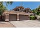 Spacious three-car garage with a concrete driveway and a partial view of the two-story home at 30 W Sheffield Ave, Gilbert, AZ 85233